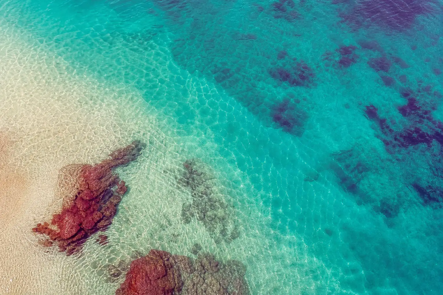 Shallow turquoise water over pale sand