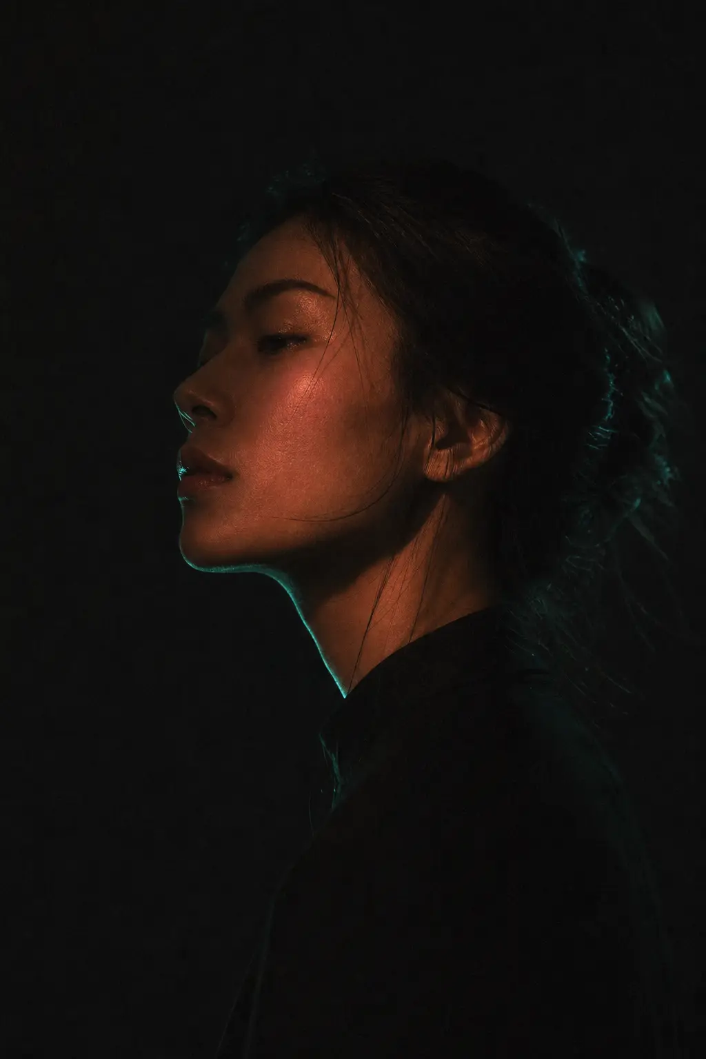 A low-key portrait of a person in profile against darkness