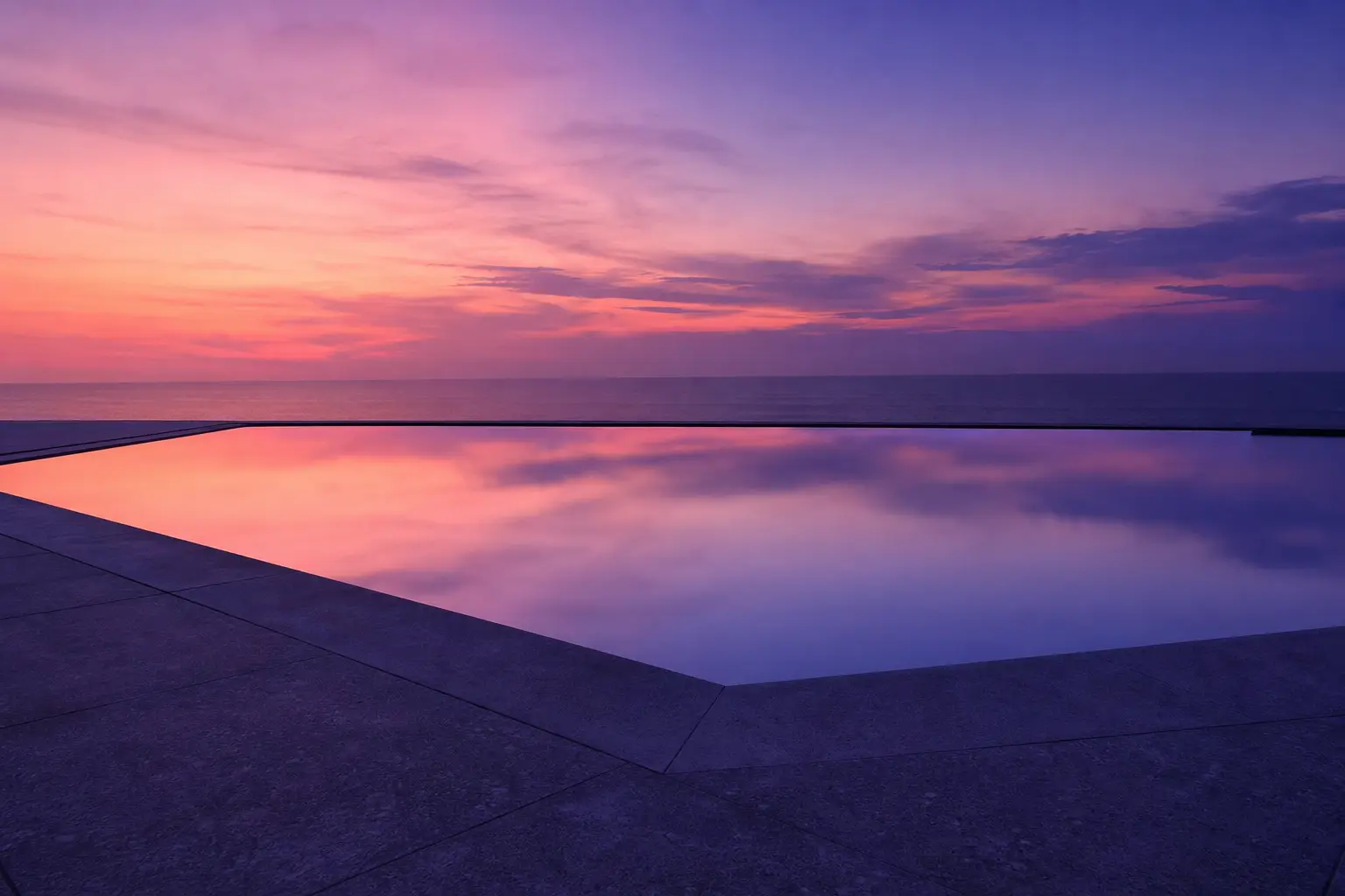 A still pool at dusk with violet light on the water