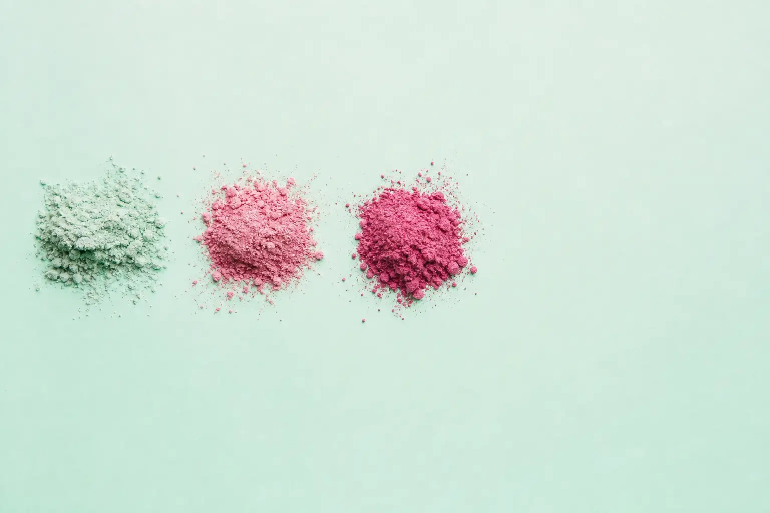 Loose pigment powders arranged in a row on a mint surface