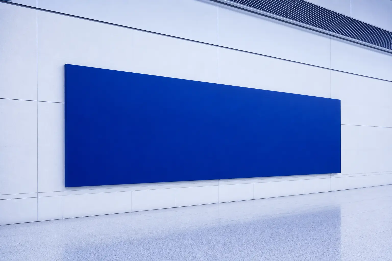 A large ultramarine wayfinding panel on a pale concourse wall